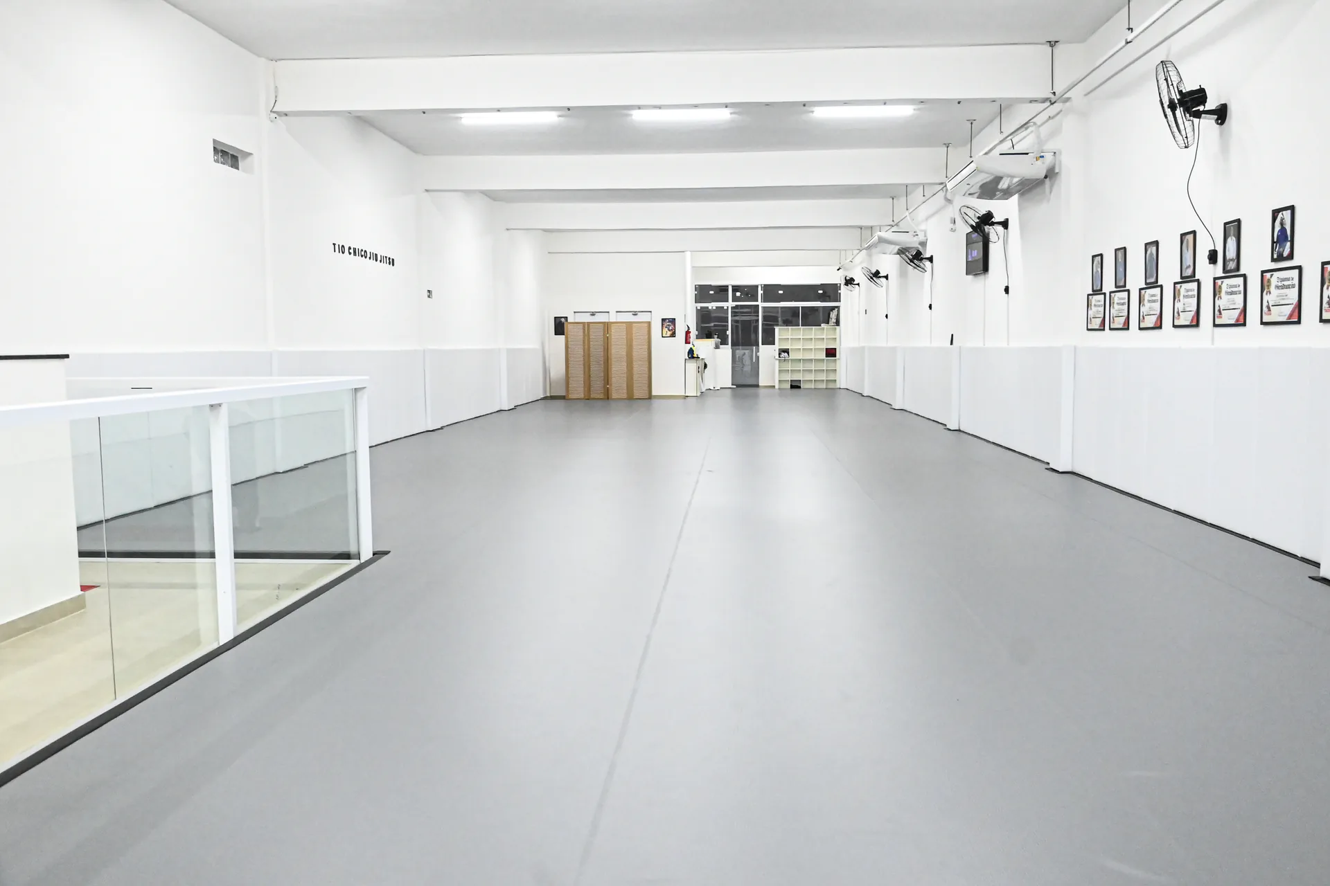 Tatame principal da Tio Chico Jiu-Jitsu em perspectiva, com iluminação de LED